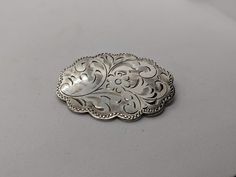 Superb vintage Burkhardt sterling silver floral engraved brooch measuring 1.5 inches long. Oval floral engraved medallion brooch with scalloped edges. There is a slight amount of tarnish on the back, the buyer can easily polish this off. It is otherwise, in great vintage condition. The back may look like it is dented, but it is not, it's most likely a reflection. I'll ensure your order is fulfilled as requested. Visit my shop at: newagainclassics.ca Ornate Oval Engraved Brooches, Oval Engraved Brooches For Anniversary, Oval Engraved Brooches For Collectors, Vintage Engraved Brooches For Anniversary, Engraved Oval Brooches For Wedding, Engraved Silver Oval Brooches, Vintage Turquoise Ring, Garnet Ring Silver, Precious Stones Rings