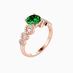 a rose gold ring with an emerald and diamonds