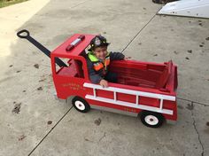 a young boy in a fire truck costume