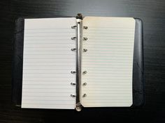 an open notebook sitting on top of a wooden table