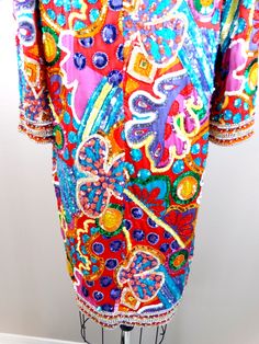 "This is a psychedelic vintage piece from Black Tie Oleg Cassini. It's fully embellished and hand beaded with colorful sequins and beads. It's in perfect condition! Size - US 10 Bust - 40\" Waist - 40\" Hips - 40\" Length - 38\" This dress comes from a pet-free and smoke-free home. If you would like more info or have any questions, please don't hesitate to ask!" Festive Multicolor Embroidered Sequin Dress, Festive Multicolor Embroidery Sequin Dress, Multicolor Fiesta Dresses For Festivals, Bohemian Embellished Festival Dresses, Multicolor Dresses For Fiesta Festivals, Bohemian Red Sequin Dress, Multicolor Dresses For Fiesta And Festivals, Traditional Dresses With Multicolor Embroidery And Sequins, Traditional Hand Embellished Multicolor Dresses