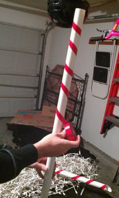 a person holding a large candy cane in their hand