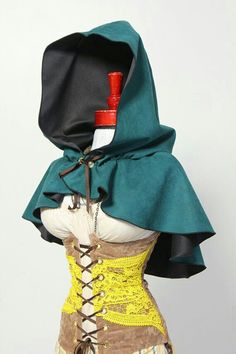 a mannequin wearing a green cape with yellow and brown laces on it