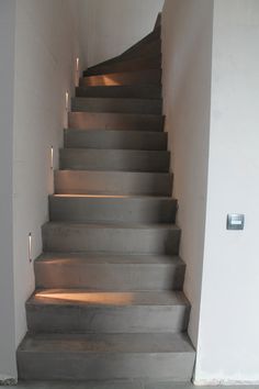 a set of stairs leading up to the top floor in a building with white walls and concrete floors