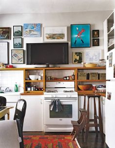 a white stove top oven sitting inside of a kitchen next to a wooden table and chairs