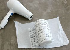 a hair dryer sitting on top of a sheet of paper next to a blow dryer