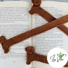 an open book with two crocheted straps on it