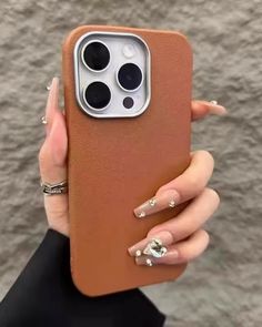 a woman holding up her phone case with nail polishes on the sides and an iphone 11