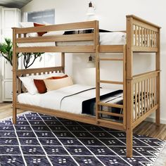 a wooden bunk bed sitting on top of a blue rug in a room with white walls