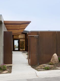 an entrance to a modern home with wooden slats on the front and side walls