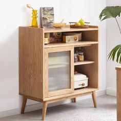 a wooden cabinet with some food on it and a potted plant in the corner