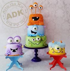 there are three cakes that look like monsters on the same cake stand as each other