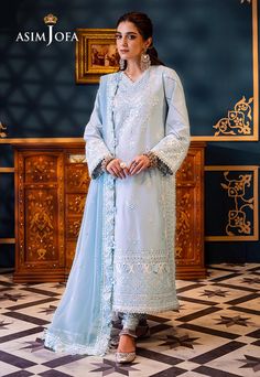 Shirt: Lawn By Pcs: 3 Pcs Trouser: Cambric Dupatta: Chiffon Color: Blue Product Details Embrace the glimmers of frost with this captivating ice blue attire adorned with intricate white and self-colored threadwork and shimmering silver 3mm sequins. Like stars in a winter sky, the neckline and borders shimmer with luxurious 9mm sequins casting a spell of enchantment. With embroidered details on the neckline, borders and sleeves, this ensemble captures the essence of frosty elegance. The embroidered border for the hemline and chaak adds a touch of winter magic while the embroidered dupatta with four-side border drapes you in the glimmers of frost. DESIGN DETAILS: Embroidered neckline for front Embroidered front with thin border on lawn Embroidered neckline for back Embroidered back with thin Casting A Spell, Batik Print Dress, Dupion Silk Saree, Side Border, Indian Anarkali, Anarkali Lehenga, Asim Jofa, Party Sarees, Lehenga Style