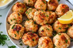 a white plate topped with crab cakes and lemon wedges