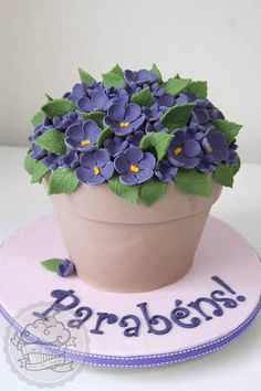 a cake decorated with blue flowers and the words parabena on it's side