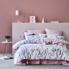 a bedroom with pink walls and marbled bedding in the foreground is an illustration of a woman's torso