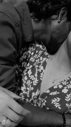 black and white photograph of a man kissing a woman's face on the cheek