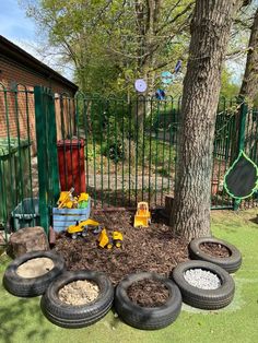 there are many tires in the yard near a tree and some other things on the ground