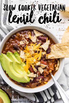 a bowl of slow cooker vegetarian chili with tortilla chips and avocado