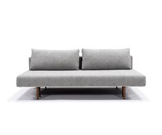 a gray couch with two pillows on it's back and one arm folded up