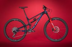 a mountain bike on a red background with the frame and seatposts folded down