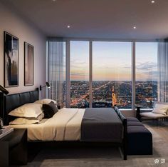 a bedroom with a large window overlooking the city at night, and a bed in front of it