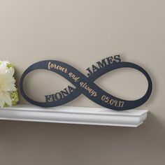 a couple of flowers sitting on top of a white shelf next to a sign that says forever and always