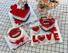 valentine's day cakes and cupcakes are displayed on a table