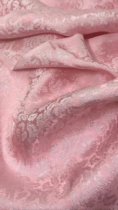 a pink fabric with white flowers on it and a light pink background that is very soft