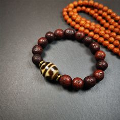 "This unique Dalo Dzi bracelet combines the mysterious and unique qualities of the tiger tooth dalo dzi and 15 old bodhi seed beads,giving it a distinct feel.  It is brown in color and has a circumference of approximately 7 inches, suitable for most wrist sizes.  This bracelet can be worn not only as a fashionable accessory but also holds cultural and religious significance. Dzi beads are precious jewelry from Tibetan culture which are believed to possess the power of bringing good fortune to th Dzi Bracelet, Tibetan Culture, Tiger Tooth, Types Of Stones, The Tiger, Precious Jewelry, Lucky Charm, Ivory White, Handmade Bracelets