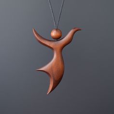 a wooden pendant with a ball hanging from it's end and a chain attached to it