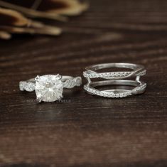 two wedding rings sitting on top of a wooden table