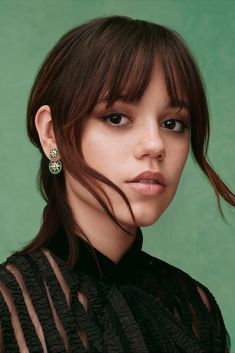 a close up of a person with long hair and earrings on her head, looking at the camera