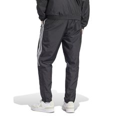 Influenced by the track but made for the streets, the adidas Tiro Woven Men's Pants have a classic style and a relaxed fit. You'll move, stretch, and bend, never feeling an ounce of restraint. Whether you want to keep your hands warm or a few of your essentials handy, you'll have pockets to do just that. Features adidas tri-stripe design. Elastic waistband. Two front pockets. Has logo on left thigh. Adidas Relaxed Fit Jogging Pants, Adidas Logo Pants With Relaxed Fit For Jogging, Black Adidas Joggers With Logo, Adidas Three Stripes Pants For Streetwear, Adidas Black Joggers With Logo, Adidas Logo Sweatpants For Training, Black Adidas Sweatpants For Streetwear, Black Adidas Logo Joggers For Streetwear, Sportswear Joggers With Three Stripes For Streetwear