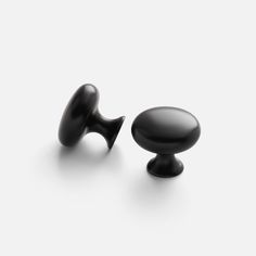 two black knobs are shown against a white background and one has an oval handle