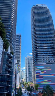 two tall buildings are next to each other on the street in front of palm trees