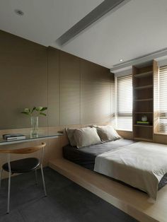 a bedroom with a bed, desk and shelves on the wall next to each other