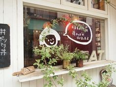 the window is decorated with plants and signs