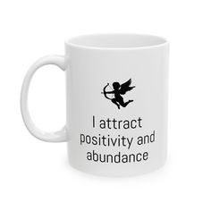 a white coffee mug with the words i attract positivity and abundance