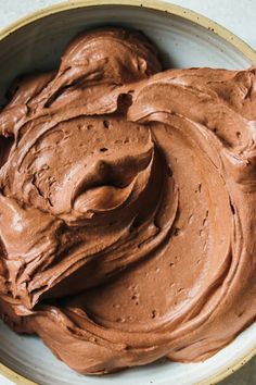 a bowl filled with chocolate frosting on top of a table