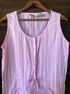 "Cutie patootie vintage 80's white and pink striped playsuit romper. Powder pink with white printed stripes and single stitched thread stripes. Short, mini dress length. Hand pockets! Cinch tie at the waist. 100% crepe feel cotton. Size medium. Has a looser, oversized fit. This thing is the best. I'm obsessed. Made by Gitano Measurements laying flat: fabric does not stretch. Length: Armpit to armpit: 20\" Waist: 18.5\" Hips: 21\" Shoulder to crotch: 30\" Inseam: 3\"" Striped Cotton Jumpsuits And Rompers For Spring, Vintage White Jumpsuits And Rompers For Spring, Pink Retro Jumpsuits And Rompers For Spring, Retro Pink Jumpsuits And Rompers For Summer, Retro Pink Summer Jumpsuits And Rompers, Pink Retro Summer Jumpsuits And Rompers, Striped Short Sleeve Jumpsuits And Rompers For Summer, Spring Striped Cotton Jumpsuits And Rompers, Sleeveless Striped Jumpsuits And Rompers For Loungewear