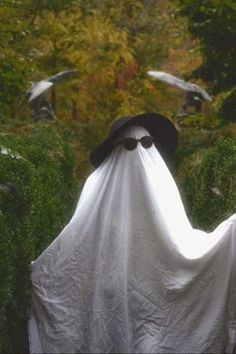 a person in a white cloak and black hat