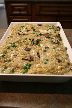 a casserole dish with peas and mushrooms in it sitting on a counter top