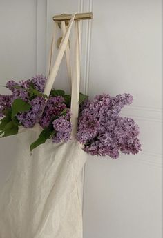 a white bag with purple flowers hanging from it