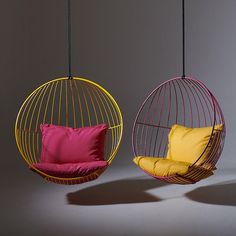 two hanging chairs with different colored cushions and one has a yellow pillow on the back