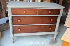 a white and brown dresser sitting on top of a wooden floor