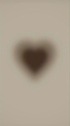 a blurry image of a heart shaped object in the middle of a gray background