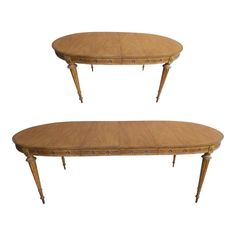 a pair of oval shaped tables with wooden legs and curved tops, each topped by an intricately carved design