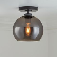 a light that is hanging from the ceiling with a glass ball on it's side