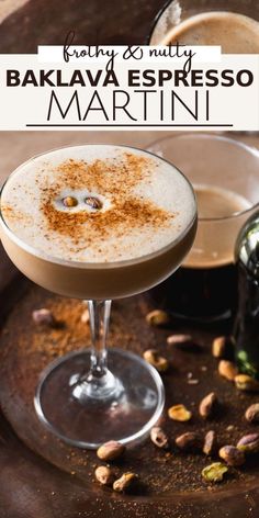 a close up of a drink in a glass on a table with nuts around it